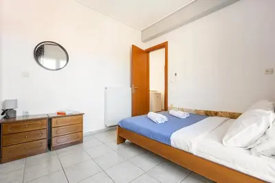 a bedroom with a bed and a dresser with a mirror at Mountain-to-Sea Oasis in Kalívia Thorikoú