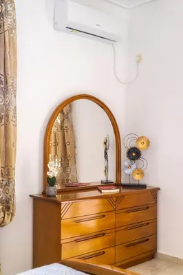 a bedroom with a dresser and a mirror at Mountain-to-Sea Oasis in Kalívia Thorikoú