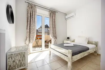 a bedroom with a bed and a large window at Mountain-to-Sea Oasis in Kalívia Thorikoú