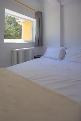 a white bed in a room with a window at dreamcatcher in Anavissos