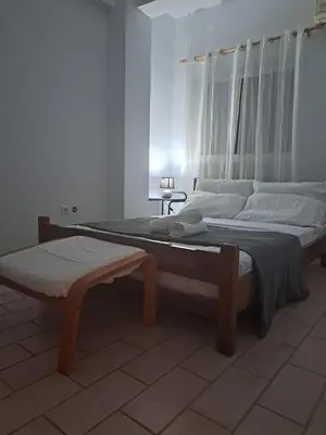 a bedroom with two beds and a bench in it at dreamcatcher in Anavissos