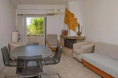 a living room with a table and a couch and a fireplace at dreamcatcher in Anavissos
