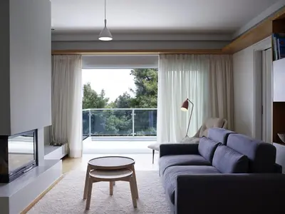 a living room with a blue couch and a table at Scale Suites in Athens