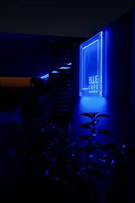 a blue sign on a building in the dark at Scale Suites in Athens