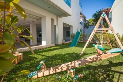 a swing in a yard with two birds on it at Scale Suites in Athens