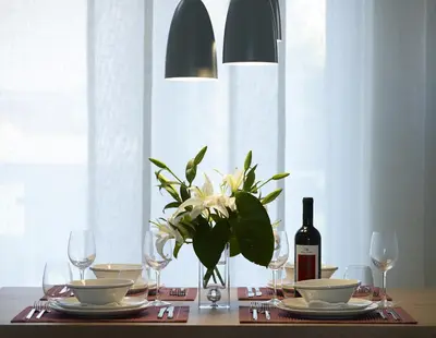 a table with a vase of flowers and a bottle of wine at Scale Suites in Athens