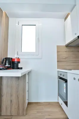a kitchen with white cabinets and a window at LIV - View and the City Studio in Athens in Athens