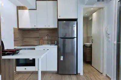 a kitchen with a stainless steel refrigerator and white cabinets at LIV - View and the City Studio in Athens in Athens