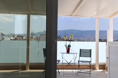 a room with a table and chairs and a large window at LIV - View and the City Studio in Athens in Athens