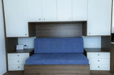 a bed in a room with white cabinets at LIV - View and the City Studio in Athens in Athens