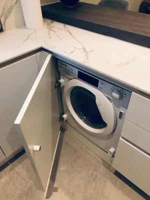 a washing machine in a kitchen under a counter at SeaRenity Glyfada Ctr, 1BR, Renovated, near beach in Athens