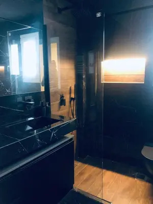 a bathroom with a sink and a glass shower at SeaRenity Glyfada Ctr, 1BR, Renovated, near beach in Athens