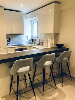 a kitchen with a counter with three stools at SeaRenity Glyfada Ctr, 1BR, Renovated, near beach in Athens