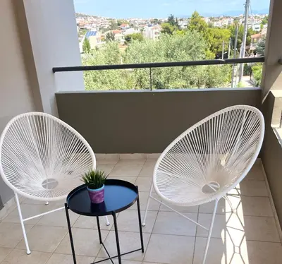 two white chairs and a table on a balcony at Amaryllis Apartments in Vravrona