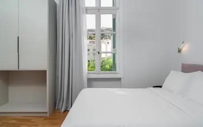 a bedroom with a white bed and a window at The Aeolian in Athens