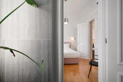 a room with a concrete wall and a bedroom with a bed at The Aeolian in Athens