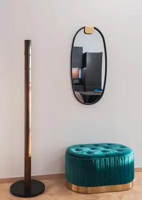 a round blue ottoman in front of a mirror at The Aeolian in Athens