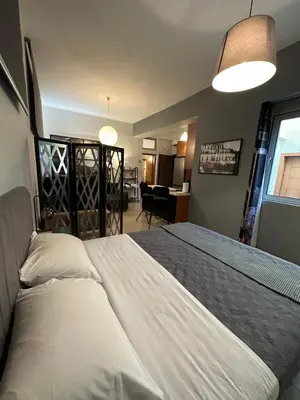 a bedroom with a large white bed and a living room at Elegant Escapes 5 in Athens