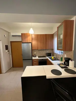a kitchen with wooden cabinets and a white counter top at Elegant Escapes 5 in Athens