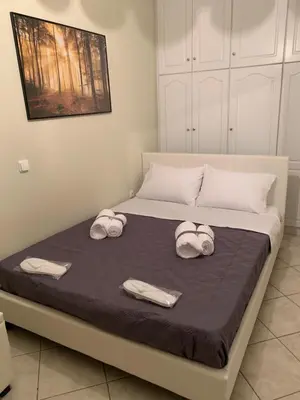 a bed with two towels and two hats on it at Elegant Escapes 3 in Athens