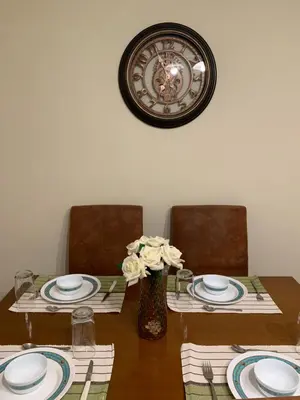 a table with two chairs and a clock on the wall at Elegant Escapes 3 in Athens