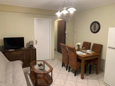 a living room with a dining room table and a kitchen at Elegant Escapes 3 in Athens