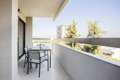 a balcony with a table and chairs and a large window at Radiant 2BR Apartment in Neo Psichiko by UPSTREET in Athens