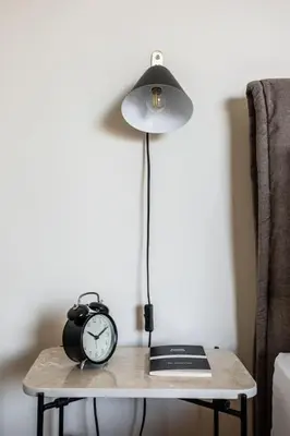 a table with a lamp and a clock on it at Radiant 2BR Apartment in Neo Psichiko by UPSTREET in Athens