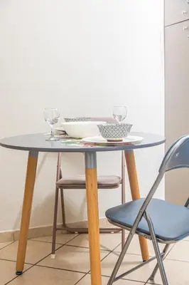 a table with two wine glasses and two chairs at Unique studio at Athens Riviera 1 min from the sea in Athens