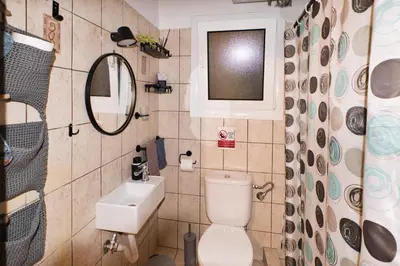 a bathroom with a toilet and a sink and a mirror at Unique studio at Athens Riviera 1 min from the sea in Athens
