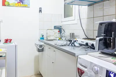 a white kitchen with a sink and a microwave at Unique studio at Athens Riviera 1 min from the sea in Athens