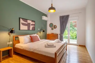 a bedroom with a large bed and a window at Boutique10 Luxury Apartment in Athens