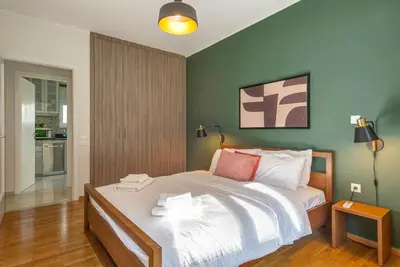 a bedroom with a large bed with a green wall at Boutique10 Luxury Apartment in Athens