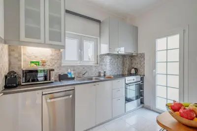 a kitchen with white cabinets and a bowl of fruit at Boutique10 Luxury Apartment in Athens
