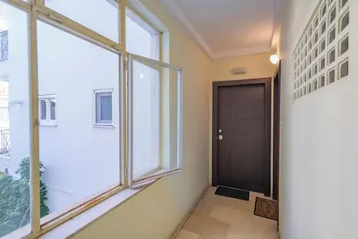 a hallway with a black door and windows at Boutique10 Luxury Apartment in Athens