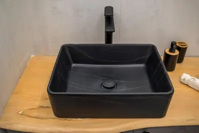 a black kitchen sink sitting on a wooden counter at V.L.A Apartments by the sea in Vari
