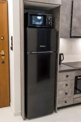 a microwave sitting on top of a refrigerator in a kitchen at V.L.A Apartments by the sea in Vari