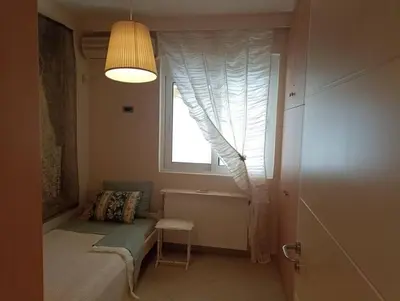 a small room with a window with a couch and a chair at Annitas luxury oasis appartment in Athens