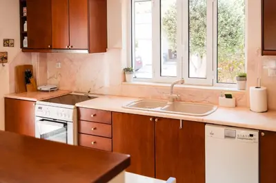 a kitchen with a sink and two windows at Luxury Cottage Casa con Vista with sea view in Sounio