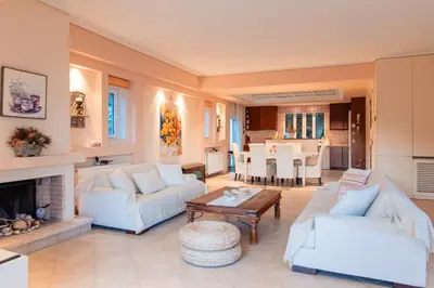 a living room with white furniture and a fireplace at Luxury Cottage Casa con Vista with sea view in Sounio