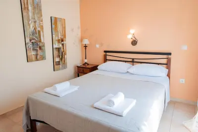 a bedroom with a bed with two towels on it at Luxury Cottage Casa con Vista with sea view in Sounio