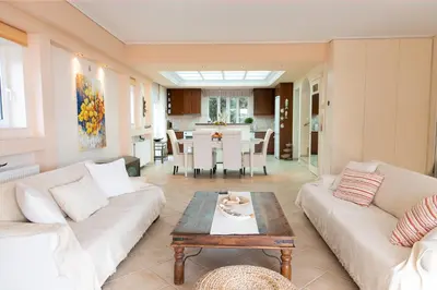 a living room with two couches and a table at Luxury Cottage Casa con Vista with sea view in Sounio