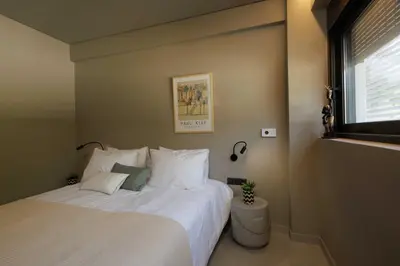 a bedroom with a large white bed with a window at Sunshine Suite by Athens Riviera Suites in Saronida