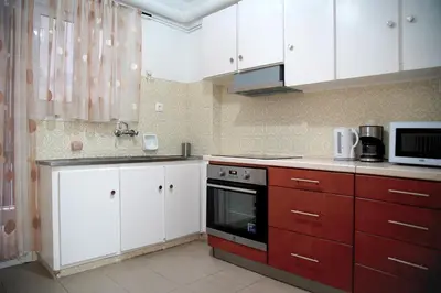 a kitchen with red and white cabinets and a microwave at Superb New Family Apartment VIPGreece in Athens