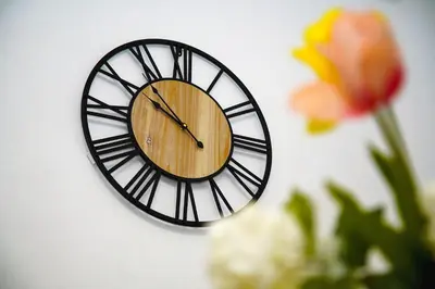 a clock on a white wall with a flower at Superb New Family Apartment VIPGreece in Athens