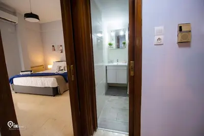 a bedroom with a bed and a bathroom with a sink at Sophia's - Central Apartment Near Egaleo Metro-Athens in Athens