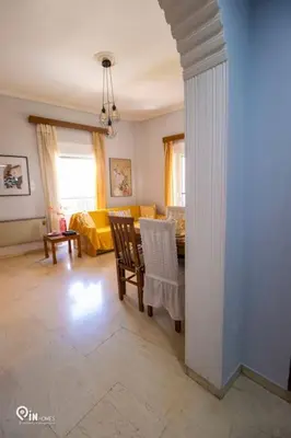 a living room with a table and a yellow couch at Sophia's - Central Apartment Near Egaleo Metro-Athens in Athens