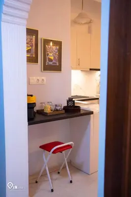 a kitchen with a red chair and a counter at Sophia's - Central Apartment Near Egaleo Metro-Athens in Athens