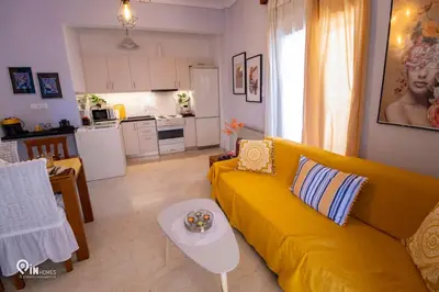 a living room with a yellow couch and a kitchen at Sophia's - Central Apartment Near Egaleo Metro-Athens in Athens