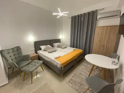 a bedroom with a bed and a table and chairs at Nafousa 1. Nafousa 2 in Athens